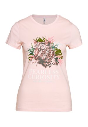 Chemise rose clair à manches courtes avec un visage de léopard, des feuilles vertes et roses, et le texte « FEARLESS CURIOSITY » en blanc sous le dessin.