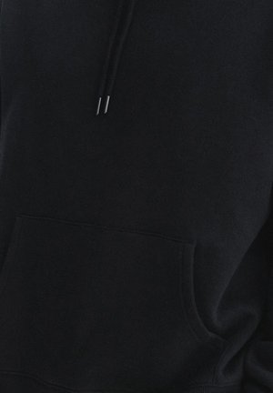 Czarna bluza z kapturem wykonana z miękkiego materiału, z przednią kieszenią, sznurkami z metalowymi końcówkami i luźnym krojem. Minimalistyczny design, bez wzorów.