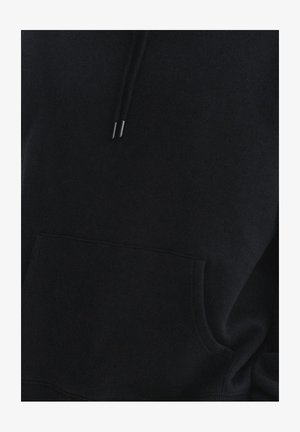 Czarna bluza z kapturem wykonana z miękkiego materiału, z przednią kieszenią, sznurkami z metalowymi końcówkami i luźnym krojem. Minimalistyczny design, bez wzorów.