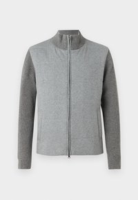 Γκρι τζάκετ με φερμουάρ, με λεία μπροστινή πλευρά και ριμπ στελέχη. Σακοραφή με στήριγμα και πλαϊνές τσέπες, σχεδιασμένο με μια απλή, μοντέρνα σιλουέτα.