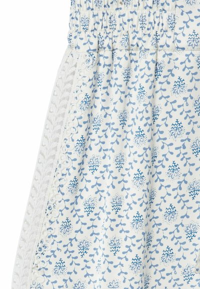 Tessuto bianco con stampa floreale blu e bordo in pizzo verticale con motivi intricati di foglie e fiori.