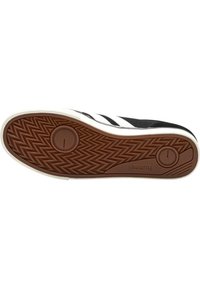 Schwarze Sneakersohle mit weißen Gummi-Kanten. Sie verfügt über ein Fischgrätmuster, zwei runde Vertiefungen und ein gummiertes Profil in Beige.