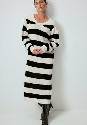 Strickkleid mit schwarzen und cremefarbenen horizontalen Streifen, oversize Schnitt, weiter Ausschnitt und langen Ärmeln. Gerippte Bündchen und Saum.