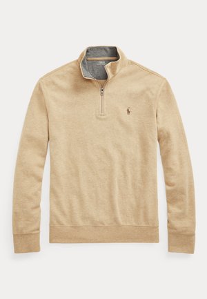 Beigen värinen pitkähihainen puolivetoketjullinen collegepaita, jossa on pystykaulus ja vasemmassa rinnassa pieni kirjailtu Polo Ralph Lauren -logo.