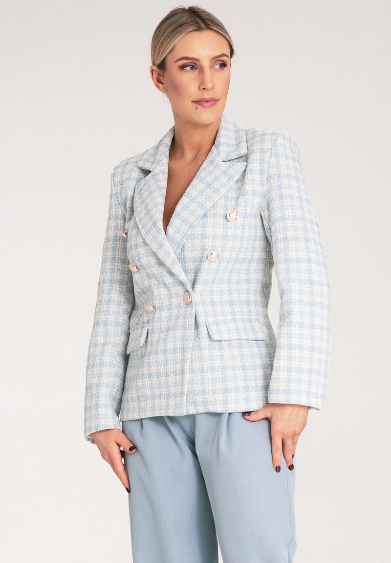 Jasnoniebieska marynarka w kratę z podwójnym zapięciem, metalowymi guzikami, klapami w szpic i dwiema przednimi kieszeniami. W zestawie z jasnoniebieskimi spodniami.