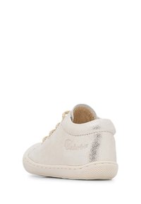 Světle zlaté kožené tenisky s texturovaným povrchem, kulatou špičkou a šněrováním. Obsahují kovový akcent na patě a prošívanou podešev.