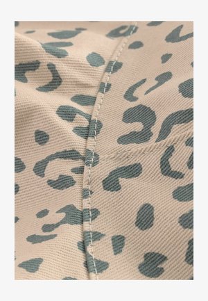 Beige kangas yenye mipango ya chora ya teali. Kushonwa kwa wazi kando ya mshono kunatoa texture. Nyenzo inaonekana kuwa imefanywa kwa uzi na sugu.