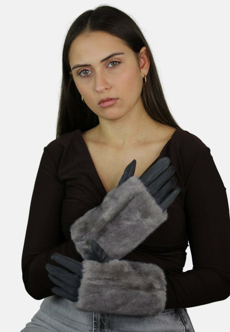 Rękawice z szarym futrzanym akcentem i czarną skórzaną podstawą, charakteryzujące się gładką strukturą oraz dopasowanym krojem, przedstawione na dłoniach skrzyżowanych na ciemnym topie.