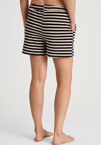 Zwart en beige gestreepte shorts met een elastische tailleband, voorzien van zijzakken en een zachte textuur, gesneden boven de knie.