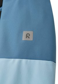 Niebieska i jasnoniebieska tkanina o gładkiej teksturze, z srebrnym logo w kształcie kwadratu z stylizowaną literą "R" na środku.