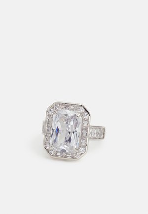 Anillo de plata con una gran piedra preciosa clara rectangular rodeada de piedras claras más pequeñas y piedras adicionales incrustadas a lo largo de la banda.
