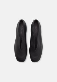 Pair of black slip-on leather shoes with a low squared toe and a deep V-shaped opening, shown from above on a white background.