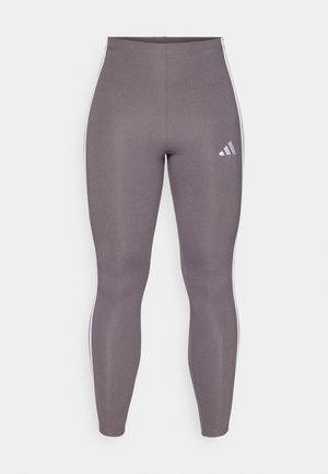 Leggings de sport gris avec une texture lisse, une coupe fuselée et des accents de rayures blanches. Présente un logo Adidas sur la cuisse gauche.