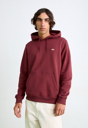 Bordeaux hoodie van zachte katoen, met een voorste kangaroo pocket en een capuchon met touwtjes. Klein logo patch op de borst. Aansluitende manchetten.