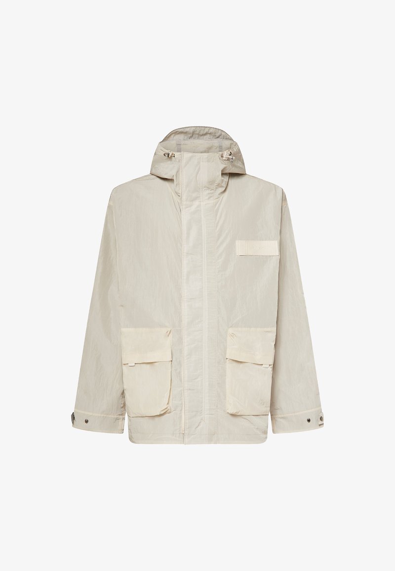Hellbeige Kapuzenjacke mit frontalem Reißverschluss, zwei großen Klappentaschen, verstellbaren Bündchen und einem kleinen rechteckigen Aufnäher auf der Brust.