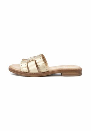 Sandalia plana de metal dorado con suela plana, parte superior texturizada, tachuelas decorativas y un acabado suave, que presenta un diseño de punta abierta.