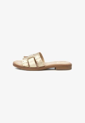 Sandalia plana de metal dorado con suela plana, parte superior texturizada, tachuelas decorativas y un acabado suave, que presenta un diseño de punta abierta.