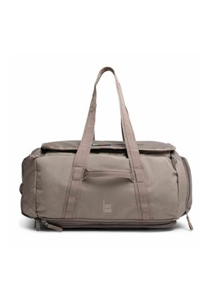 Beige Duffel-Tasche mit zwei Griffen, vordere Reißverschlusstasche, Seitentaschen und "GOT BAG"-Logo in der Mitte vorne.
