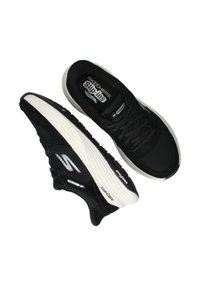 Zwarte Skechers instapsneakers met een bovenwerk van mesh, een gevoerde kraag en een witte rubberen zool met textuur voor grip en een logo-detail.