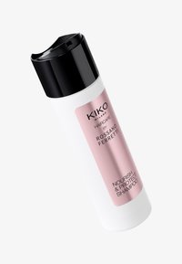 Vit plastflaska för schampo med svart kork. Etiketten har rosa detaljer och svart text med orden "NOURISH & PROTECT SHAMPOO."