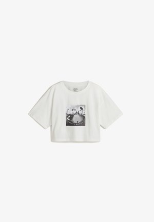 Weißes, kurz geschnittenes T-Shirt aus Baumwolle. Mit einem schwarz-weißen Grafikdruck, der zentral auf der Vorderseite platziert ist und Palmen sowie ein Skateboard-Motiv zeigt.