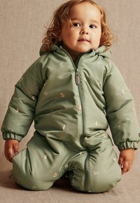 Groen gevoerd sneeuwpak met een ritssluiting, voorzien van kleine dierenpatronen, geribde manchetten en een capuchon voor warmte en bedekking. Zachte textuur.