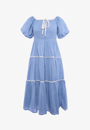 Lichtblauwe jurk met witte stippen, opgepofte korte mouwen, geplooid lijfje, gelaagde rok en een detail met strikje bij de hals.