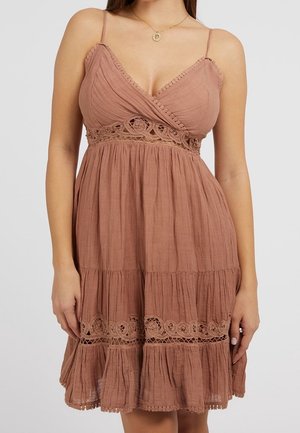 Robe marron sans manches avec un décolleté en V, en tissu texturé, avec des accents en dentelle à la taille et une jupe à plusieurs niveaux avec un ourlet volanté.