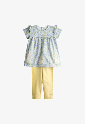 Vestito floreale blu con maniche a volant e conigli ricamati, abbinato a pantaloni gialli con bottoni decorativi sui polsini.