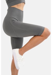 Shorts da bicicletta grigi alti in vita realizzati in tessuto morbido, con un design aderente, taglio fino al ginocchio e sottili dettagli texture.