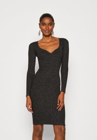 Black, long-sleeve dress with a scoop neckline, made from a sparkly, textured fabric that fits snugly and has a knee-length hem.