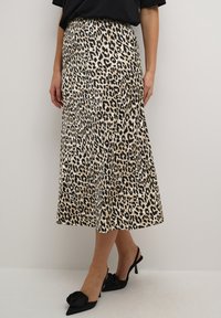 Leopardenmuster Midi-Rock mit einer glatten, satinierten Textur, hoher Taille und ausgestellter Silhouette. Schwarze Slingback-Absätze vervollständigen den Look.