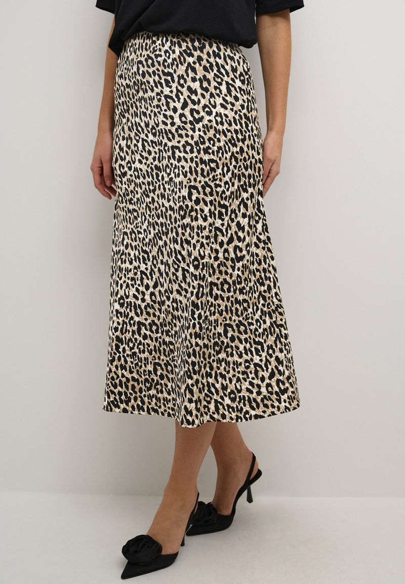 Leopardprint midi-rok met een gladde, satijnen textuur, voorzien van een hoge taille en een uitlopende snit. Zwarte slingback hakken accentueren de look.