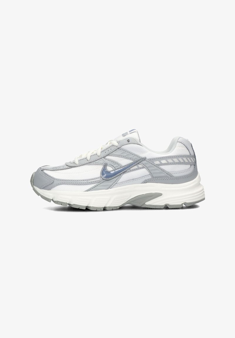 Nike running shoe featuring a mix of grey and white mesh material, with a textured sole, and reflective accents on the sides.
