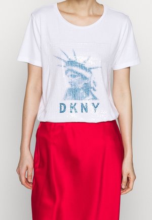 T-shirt en coton blanc avec un design en sequins bleus de la Statue de la Liberté et le texte "DKNY" en dessous, à manches courtes et col rond.