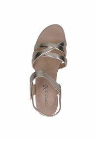 Metalické zlaté sandály s designem křížových popruhů, otevřenou špičkou a měkkou béžovou stélkou. Mají nízký podpatek a hladký povrch.