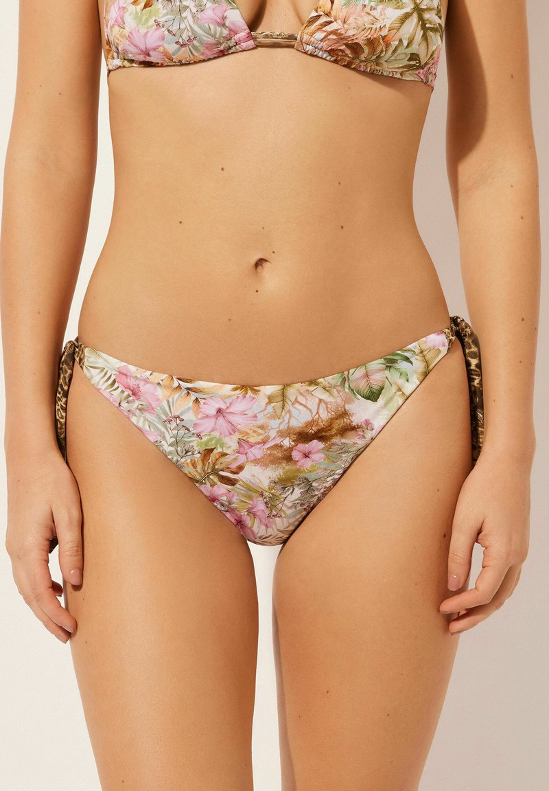 Kwiatowy bikini w pastelowym wzorze z różowymi i zielonymi akcentami. Regulowane boczne wiązania z kontrastującym zwierzęcym nadrukiem na brzegach.