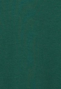 Texture de tissu vert foncé uni avec un motif de tricot fin visible.