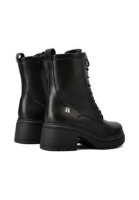 Stivali ankle in pelle nera con lacci frontali, zip laterale, tacco spesso e dettagli con logo sul lato. Suola testurizzata per una migliore aderenza.