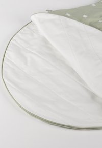 Runder gepolsterter Matratze mit weichem weißem Innenfutter und hellem grünen Außenstoff mit weißen Tiermustern und einem Reißverschluss.