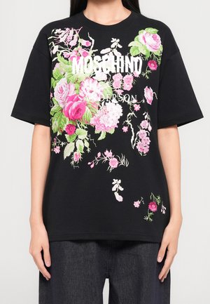 Zwarte oversized T-shirt met grote roze en witte bloemenprint en witte tekst met Moschino Sanderson op de borst.