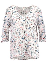 Blusa de estampado floral con escote en V, mangas tres cuartos y un corte holgado. Presenta flores rosas, azules y verdes sobre un fondo claro.