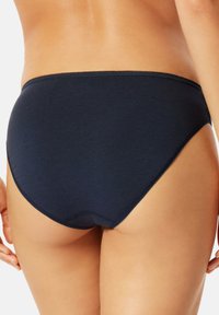 Marineblaue Baumwollunterwäsche mit glatter Textur, hoch geschnittenen Beinausschnitten und einem weichen elastischen Bund. Minimalistisches Design ohne sichtbare Markenkennzeichnung.