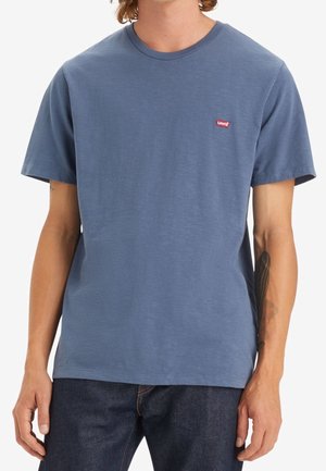 Kortærmet blå T-shirt lavet af bomuld, med rund halsudskæring og et lille rødt Levi's-logo på brystet. Glat tekstur.