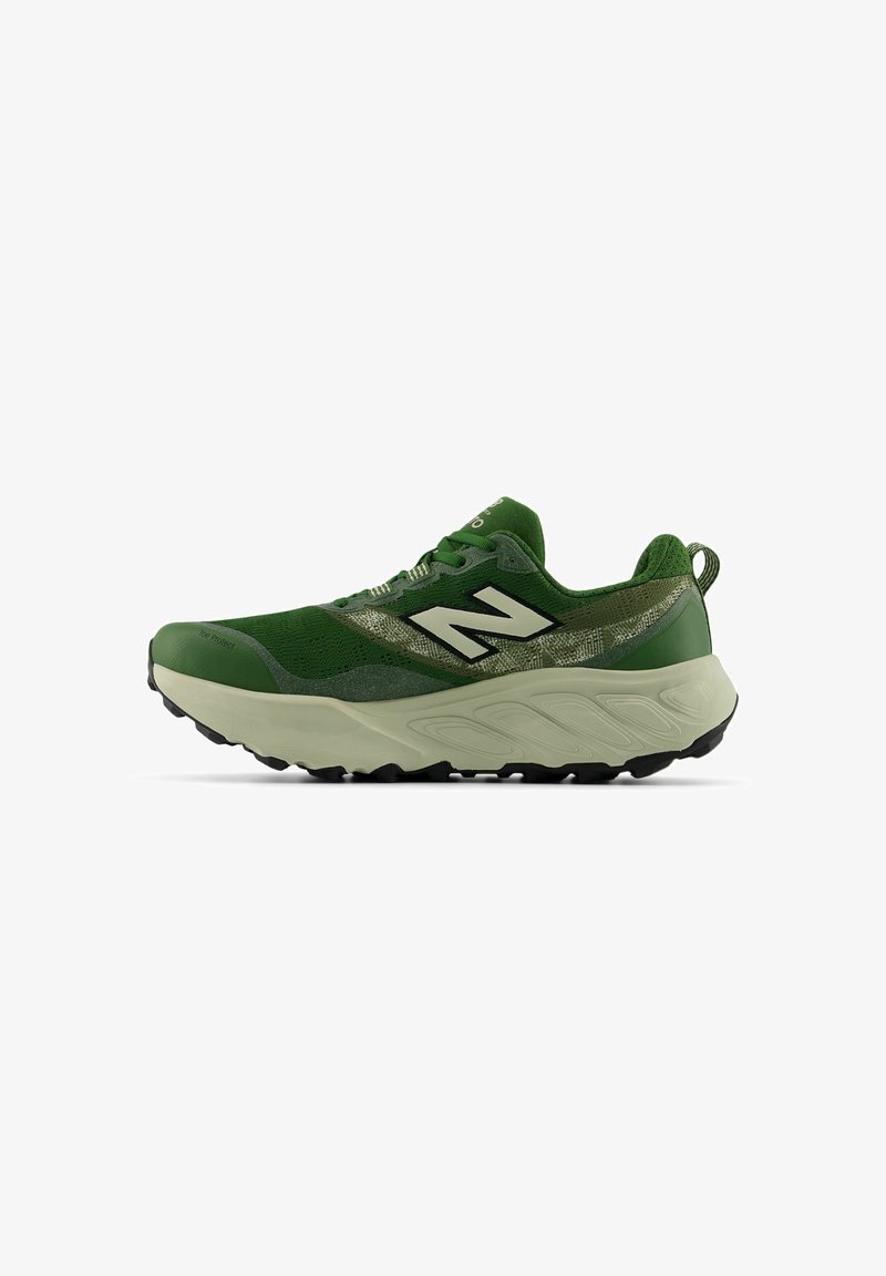 Zapatilla deportiva verde con suela gruesa beige, dibujo negro en la parte inferior, y logo blanco "N" en el lateral, vista desde el lado exterior.