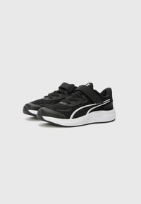 Baskets de sport noires avec tige en mesh, collier rembourré et sangle réglable en Velcro. Accents blancs le long des côtés et semelle en caoutchouc.