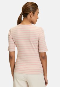 Striped short-sleeve top in soft beige with pale pink stripes. Features a round neckline and ribbed texture. Close-fitting design.