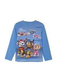 Langärmliges blaues Hemd mit animierten Hunden in bunten Outfits, mit einem Hintergrundgrafik von Himmel und Flugzeug. Aus Baumwolle.