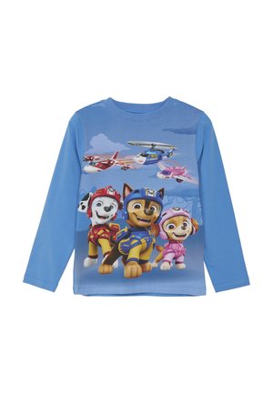Langärmliges blaues Hemd mit animierten Hunden in bunten Outfits, mit einem Hintergrundgrafik von Himmel und Flugzeug. Aus Baumwolle.