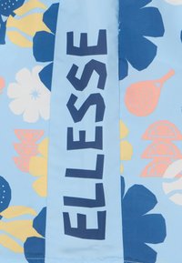 Zila auduma, kurā ir dažādi ziedu un augļu raksti. Izteikts "ELLESSE" logs tumši zilā krāsā uz gaišā fona.